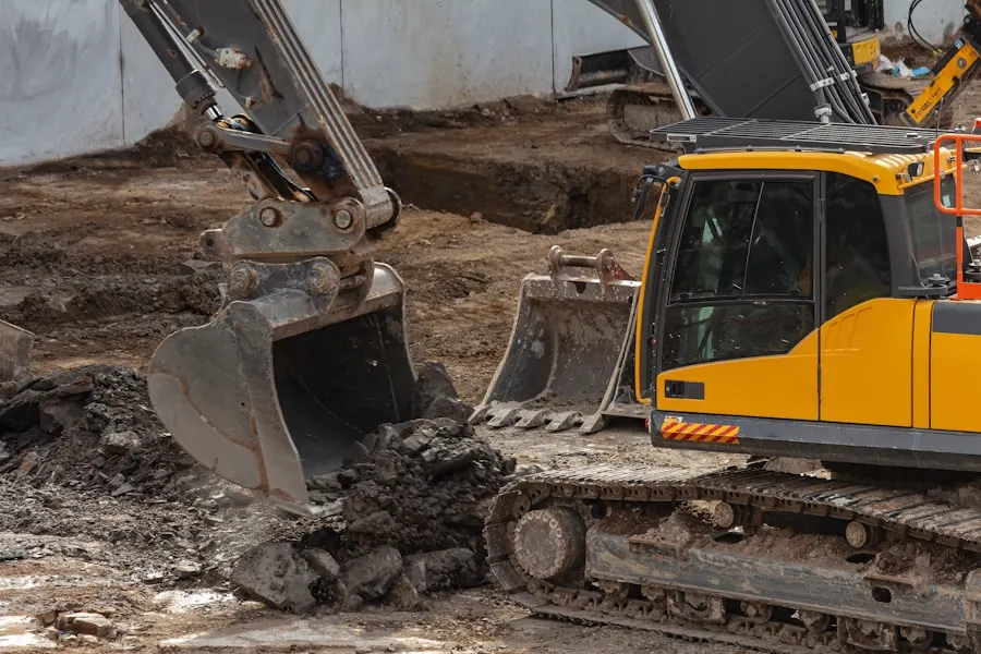 Excavator buckets moving dirt on a graded pad